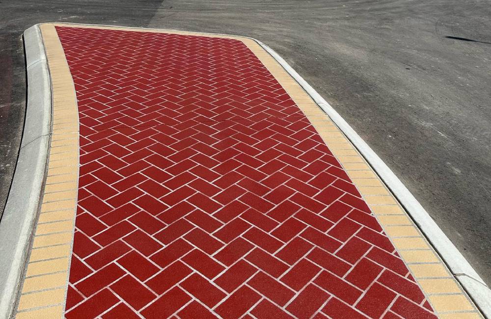 A roundabout with bold red and cream high-friction paving surfaces for safety and visibility.