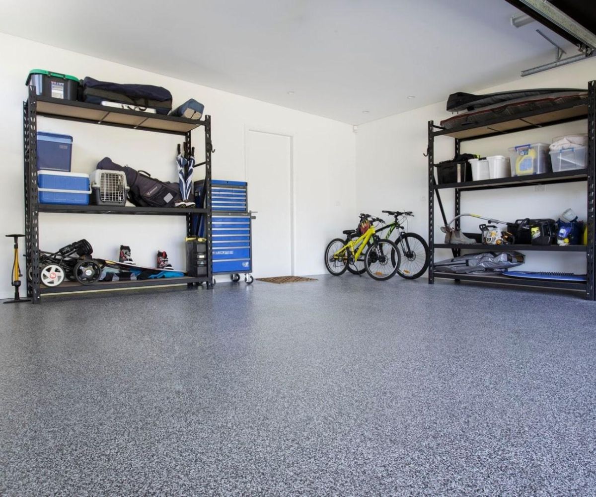 White epoxy flooring with black and grey flake finish in a garage, enhancing style and slip resistance.