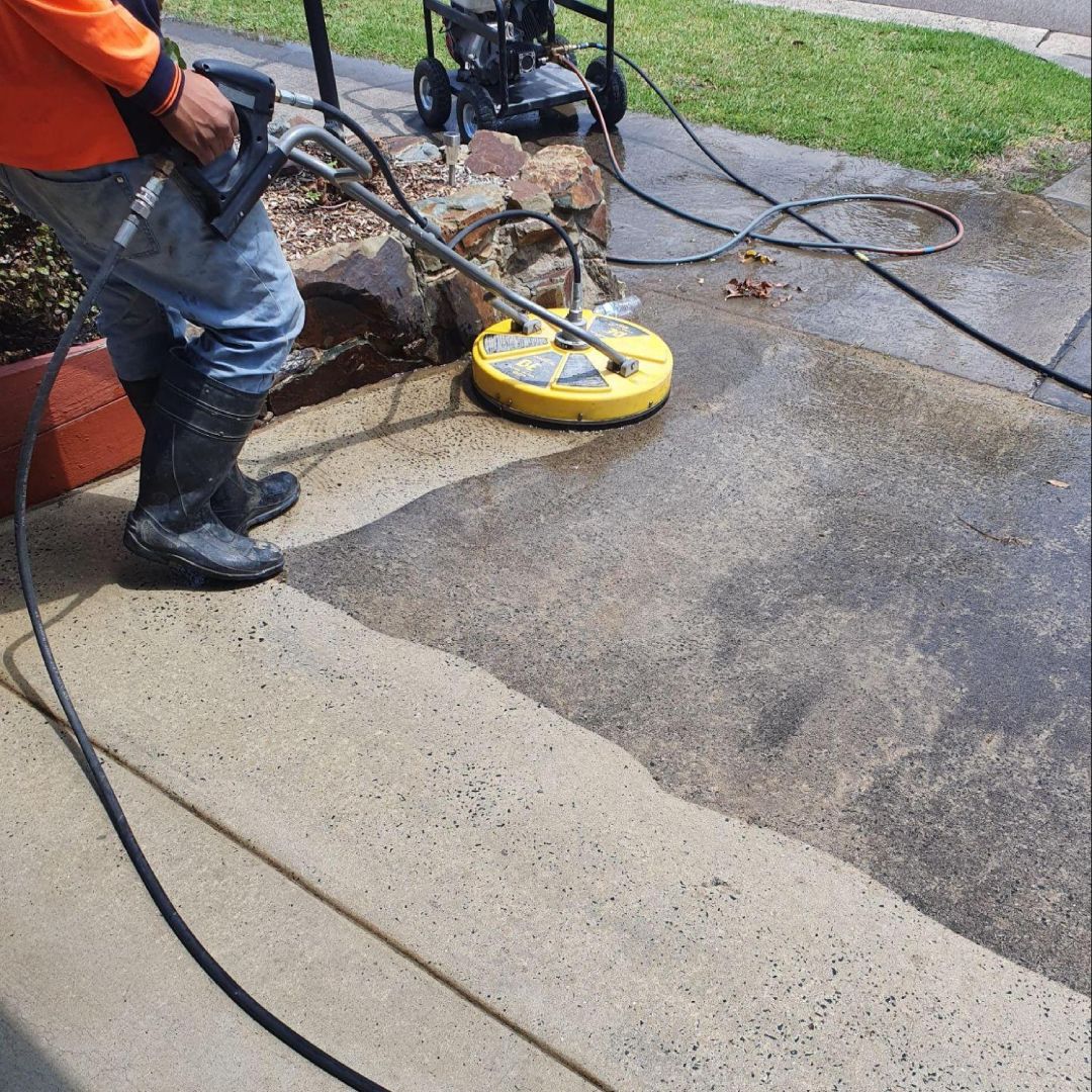 Close-up of high-pressure cleaning removing grime from concrete surface