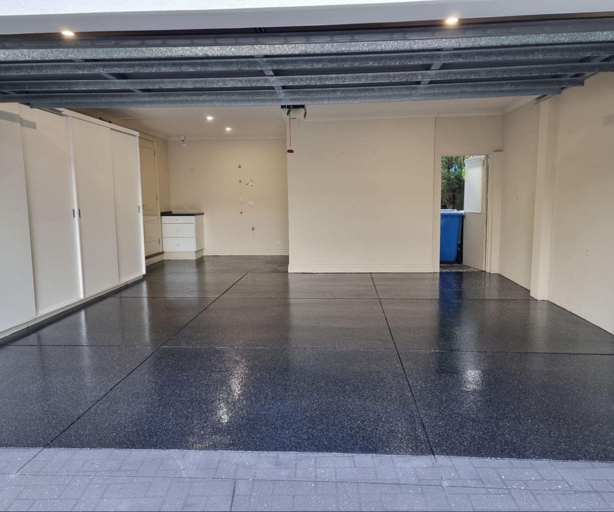 Dark grey epoxy flake garage flooring with a smooth, durable finish, perfect for high-traffic areas.