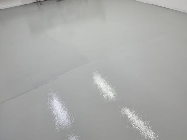 Chemical-resistant industrial floor coating in a lab or wash bay