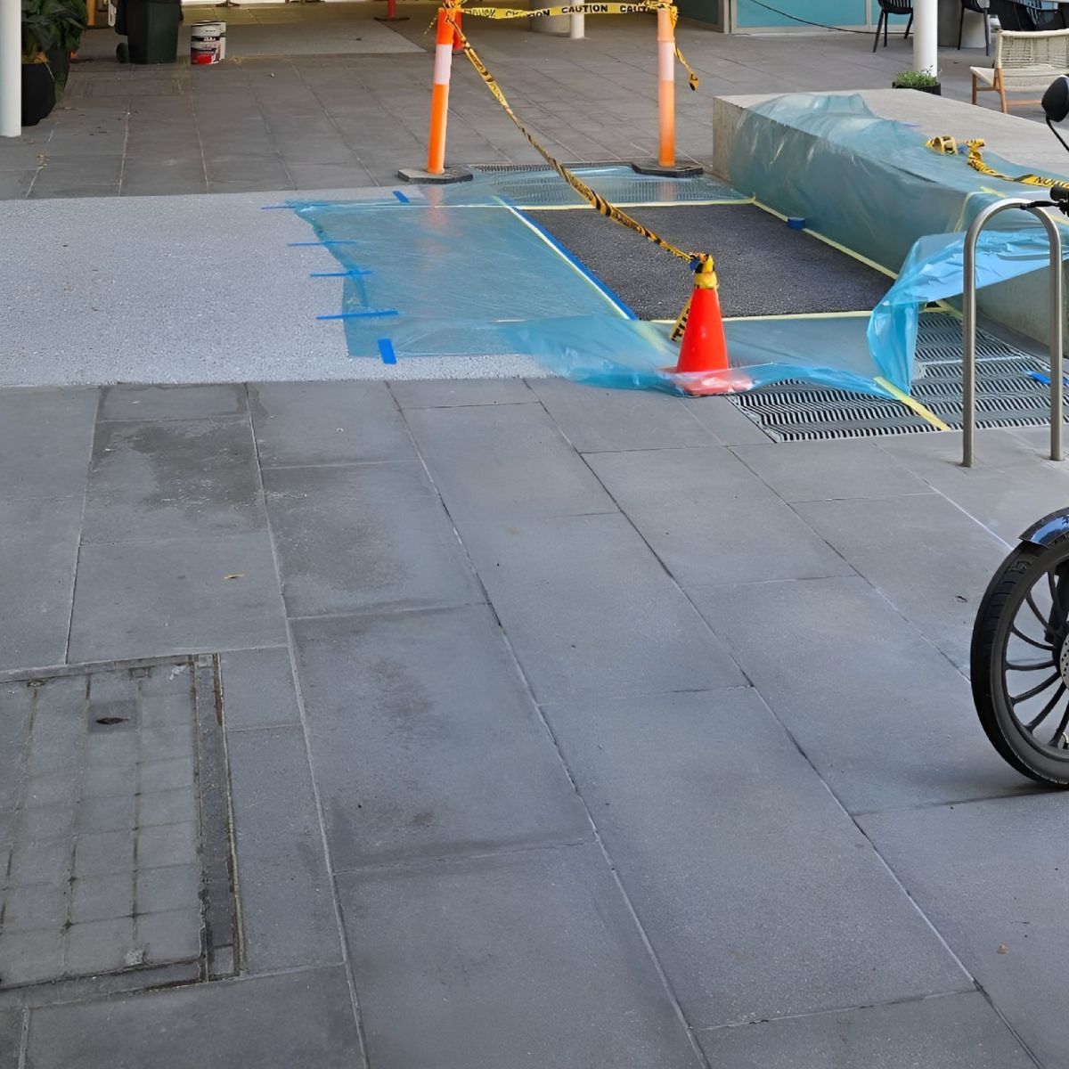 Asphalt coating applied at a commercial entry area in Melbourne, under a timber roof structure.