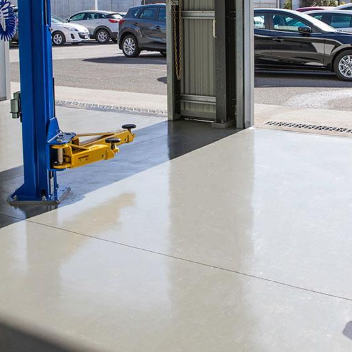 Smooth industrial concrete floor coating inside an automotive service workshop in Melbourn