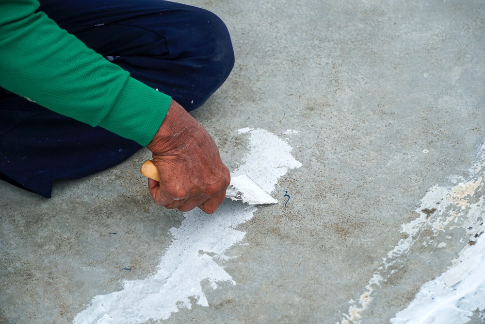 Repairing and sealing cracks in a concrete driveway before resurfacing
