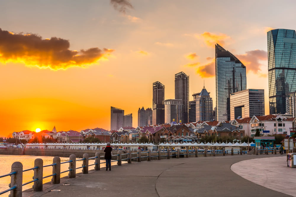 Melbourne, Victoria, Australia waterfront skyline at sunset with modern buildings and a riverside promenade
