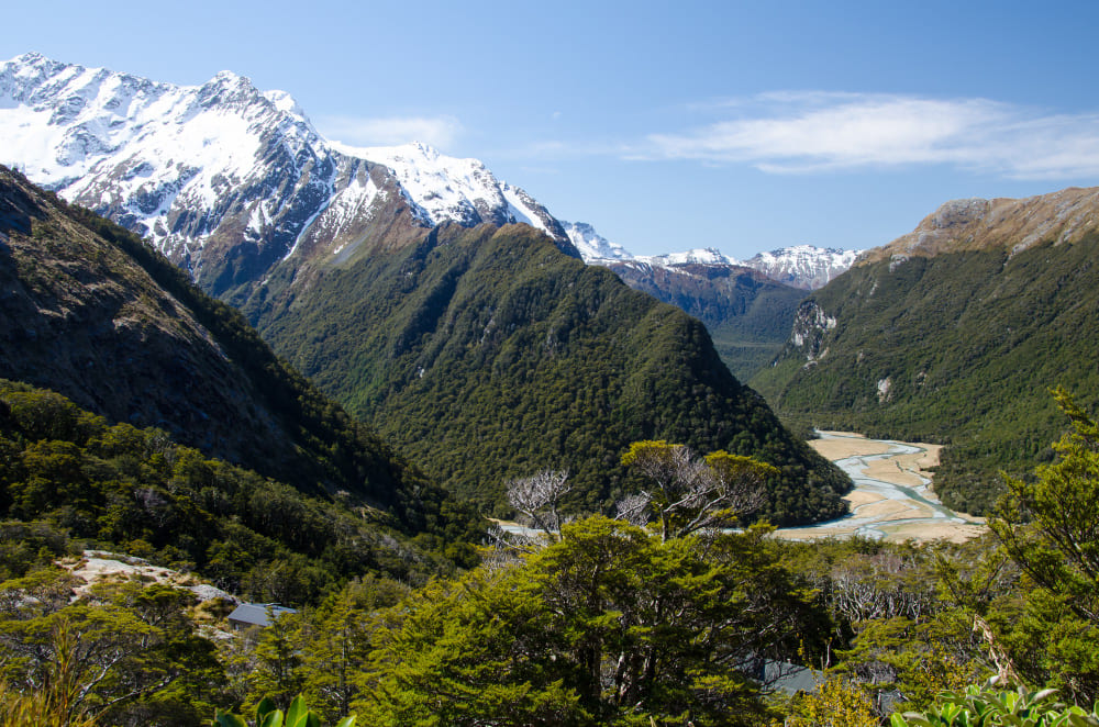 Mount Eliza mountain valley with a winding road and snow-capped mountains