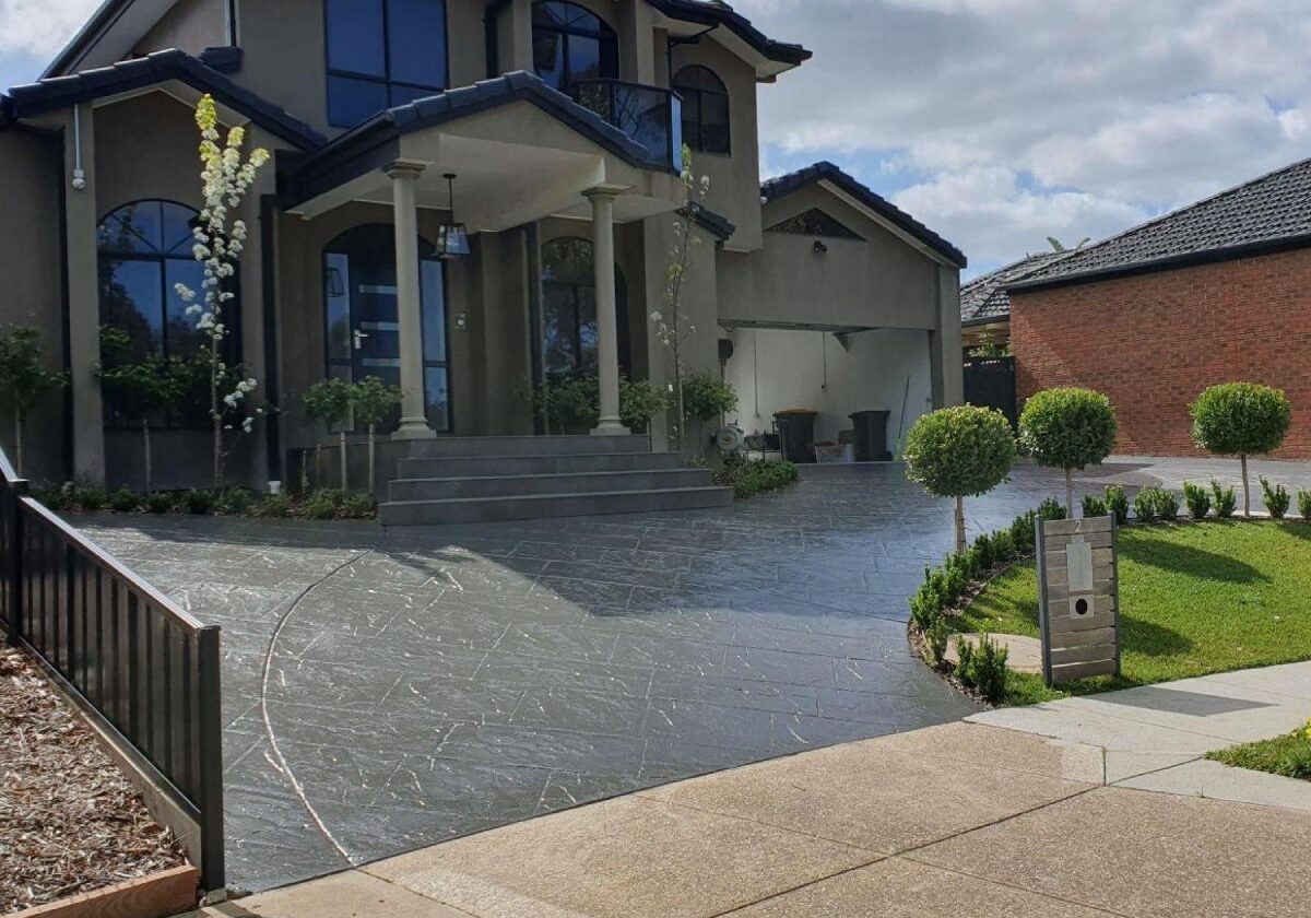 Clear and coloured decorative concrete driveway at a luxury two-storey home in Melbourne.