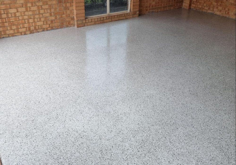 Grey epoxy flake flooring in a modern kitchen, providing a decorative and durable surface that hides everyday wear.
